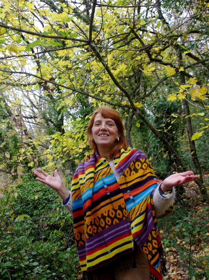 Florence Albouy, souriante, les bras ouverts, dans le parc en automne